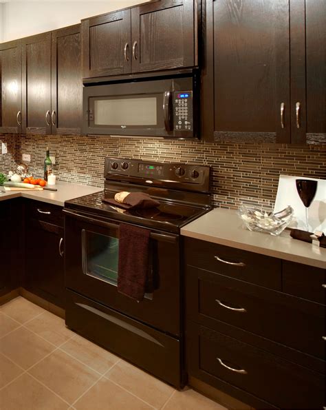 dark brown kitchen cabinets with stainless steel appliances|brown cabinets with black countertops.